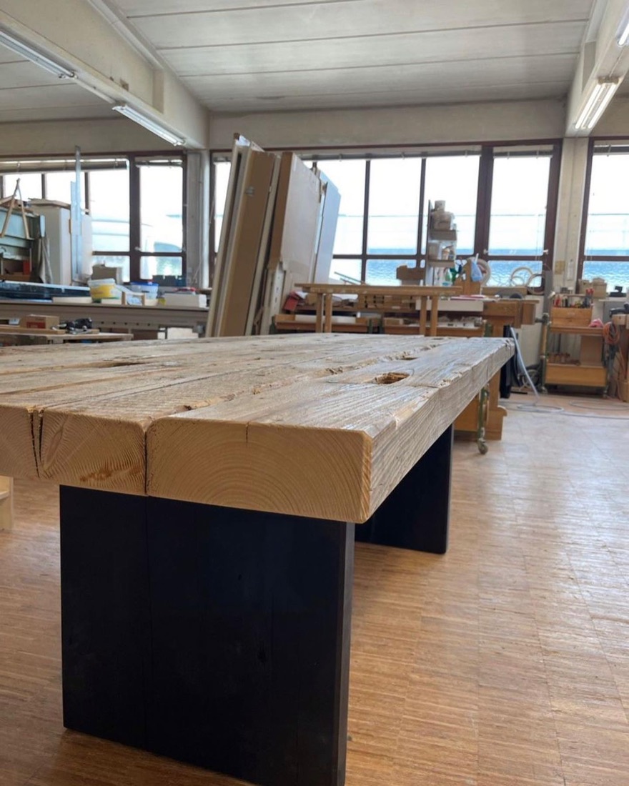 Tischplatte auf schwarzen Wangen in der Werkstatthalle